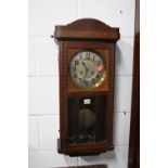 AN OAK CASED WALL CLOCK (key and pendulum)