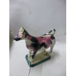 A 19TH CENTURY STAFFORDSHIRE PEARLWARE COW CREAMER, sponge decorated in pink and black on canted