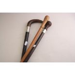 A TAPERING HARDWOOD WALKING CANE, with turned knop over silver collar, London 1914, together with