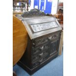 A VICTORIAN CARVED OAK WRITING BUREAU, with four drawers and cupboard base
