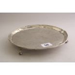 A CIRCULAR SILVER SALVER, with beaded rim, floral and leaf central decoration on three claw and ball