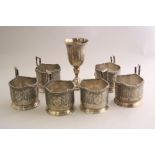 SIX WHITE METAL CUP HOLDERS, with shaped floral rim, stylised floral decoration to body, impressed