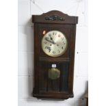 AN OAK CASED WALL CLOCK (key and pendulum)