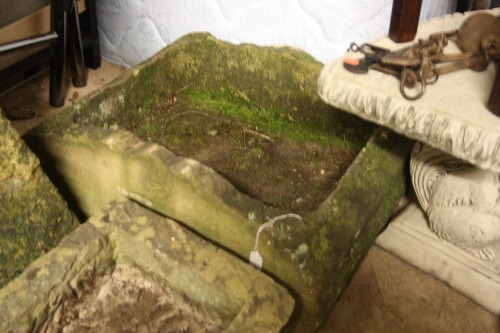 A STONE TROUGH WITH ARCHED SIDES