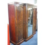 A VICTORIAN MAHOGANY BREAKFRONT TRIPLE DOOR WARDROBE, with central mirrored door, approximate size
