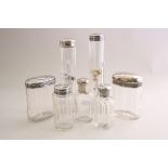 A SET OF FOUR SILVER TOPPED GLASS DRESSING TABLES BOTTLES, all monogrammed, tallest 18cm, an oval