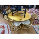 A PINE CIRCULAR KITCHEN TABLE AND FOUR CHAIRS, with seat pads (5)