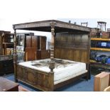 A CARVED OAK FOUR POSTER BED, panelled backboard with turned front columns, approximate size