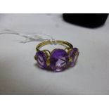 A 9CT GOLD AMETHYST RING, with three oval shape amethyst to the plain tapered band, stamped 9k, ring