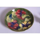 A MOORCROFT POTTERY FOOTED DISH, Hibiscus pattern on green ground, impressed marks and painted