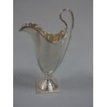 A SILVER HELMET SHAPED CREAM JUG, with high loop handle on square plinth, London 1937, approximately