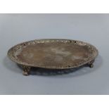 AN OVAL SILVER TRAY, with pierced floral border, beaded rim, central swag decoration set on four