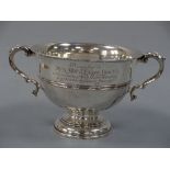 A TWIN HANDLED SILVER PRESENTATION FOOTED BOWL, inscribed 'Presented to Dr & Mrs J Ensor Trout on