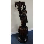 A CARVED HARDWOOD BLACKAMOOR STAND, having female figure leaning on vine with moulded leaf mounts,