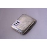 A SILVER CIGARETTE CASE, having floral and scroll engraved detail to vacant shield cartouche with