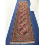 A RED AND BLUE GROUND CARPET RUNNER, approximate size 375cm x 93cm