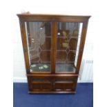 AN 'OLD CHARM' CARVED OAK LEAD GLAZED TWO DOOR DISPLAY CABINET, with solid cupboard below,