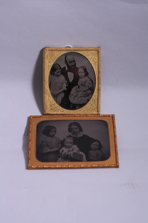 TWO DAGUERREOTYPE FAMILY PORTRAITS, in gilt frames, oval example with father and daughters,