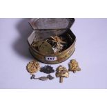 A SMALL TIN CONTAINING A NUMBER OF WWI ERA MILITARY CAP BADGES, etc, to include Kings Own Scottish