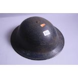 A BRITISH WWII ERA TOMMY STYLE TIN HELMET, complete with lining and strap, black coloured,