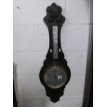 A CARVED OAK WALL BAROMETER