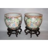 A PAIR OF CHINESE FAMILLE VERTE FISH BOWLS, decorated with figural panels in between flowers and