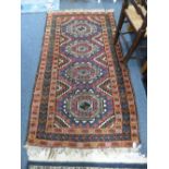 A RED GROUND RUG, with central medallion design, approximate size 175cm x 98cm