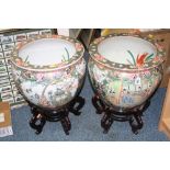 A PAIR OF CHINESE FAMILLE VERTE FISH BOWLS, decorated with figural panels in between flowers and