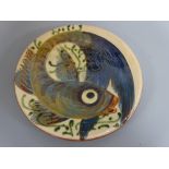 A PUIGDEMONT SLIPWARE CIRCULAR WALL PLAQUE, decorated with fish, signed verso, approximately 32cm