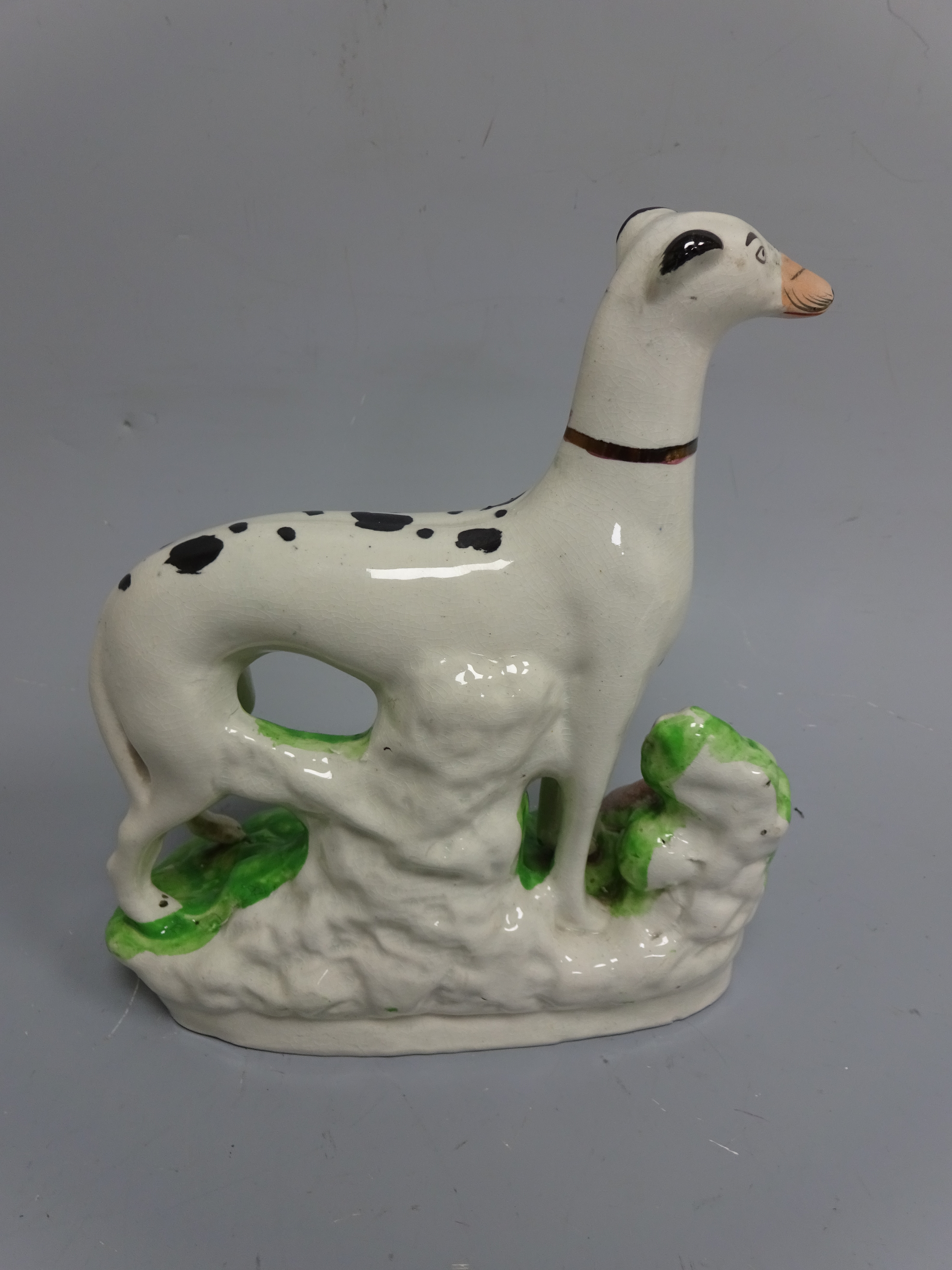 A STAFFORDSHIRE FIGURE, modelled as standing black and white spotted greyhound with dead hare, set - Image 2 of 2