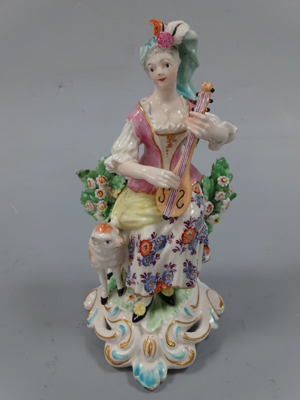 AN 18TH CENTURY DERBY FIGURINE, c.1765-70, musical shepherdess, modelled as shepherdess sat on