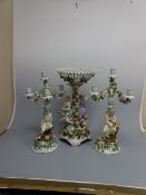 A GERMAN GARNITURE, having central table centre with pierced fluted bowl over figures and cherubs on