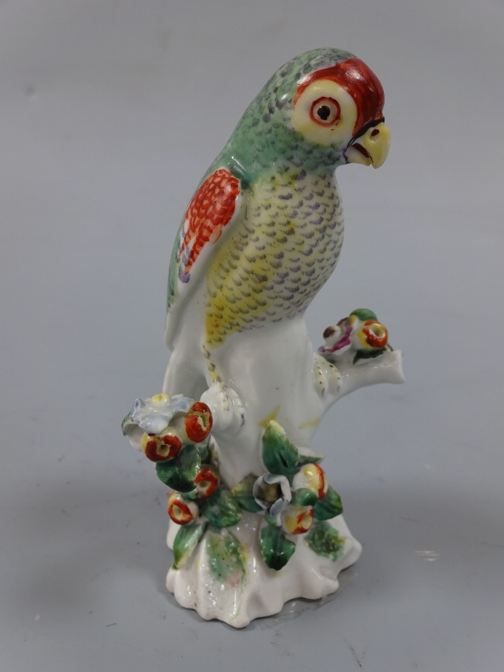 A DERBY PARAKEET FIGURE, c.1765, on floral encrusted branch, approximately 9.5cm high (a/f) (D.