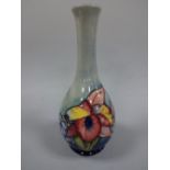 A MOORCROFT FOOTED BOTTLE VASE, with flared neck, tube line decorated with frilled orchid pattern to