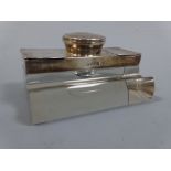 A DESK INK STAND, having shaped rectangular glass base with pen recess and silver mounted central
