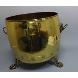 A BRASS COAL BUCKET, having lion mask and ring carrying handles set on three paw feet with copper