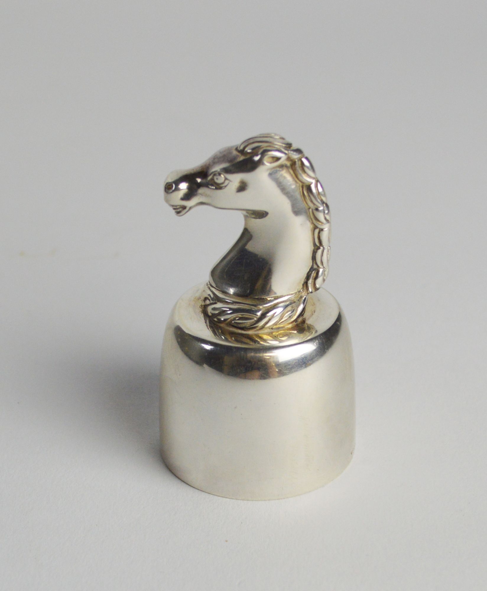 A Hermes silver plated wine bottle top surmounted with a horses' head, stamped 'Hermes Paris',