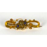 A Victorian 9ct gold and sapphire set brooch, of scrolled form,