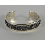 A silver torque style bangle, with textured crumpled design and polished border, approx 25.