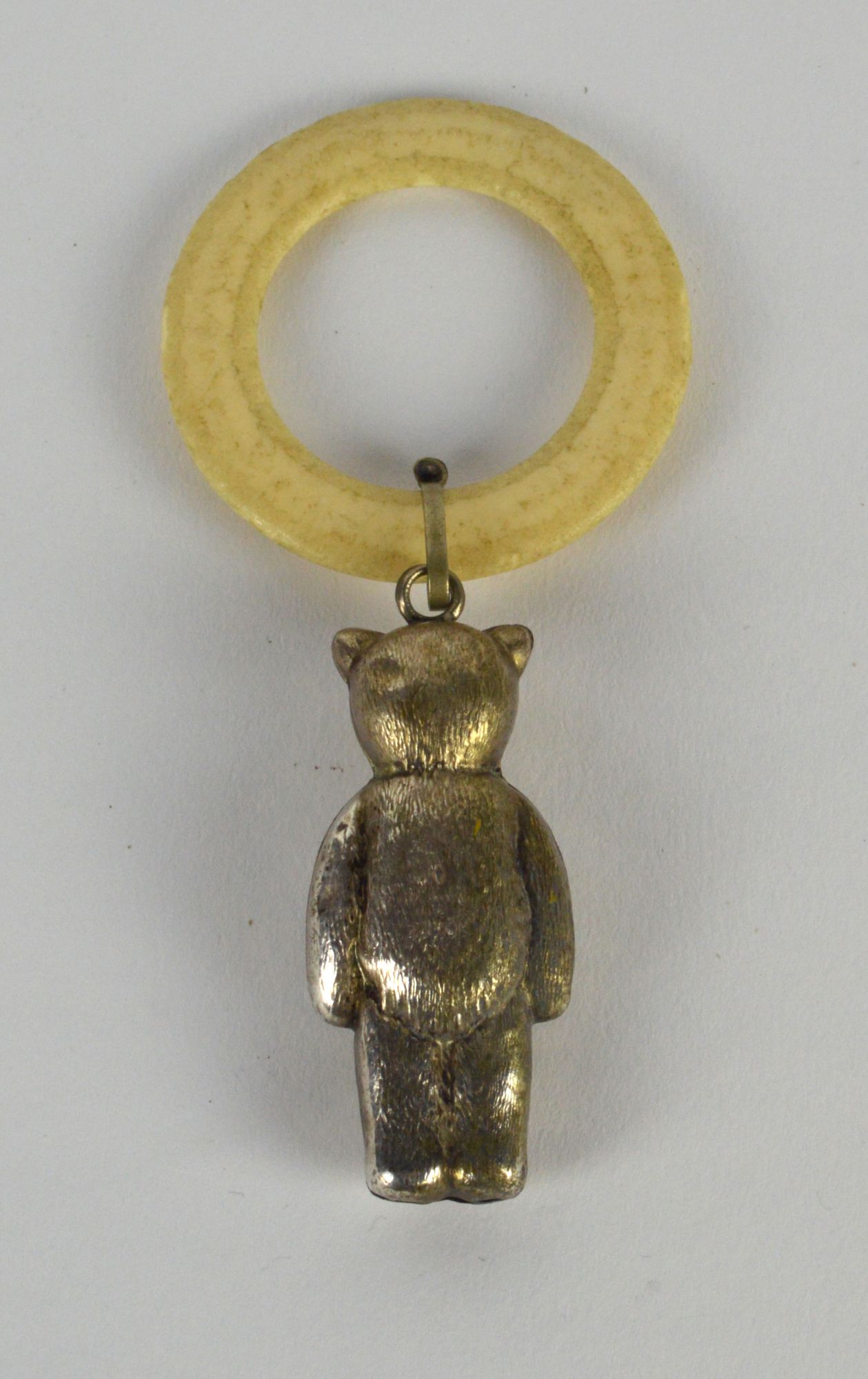 A silver plated babies teether, the ivory coloured plastic ring hung with a teddy bear. - Image 2 of 2