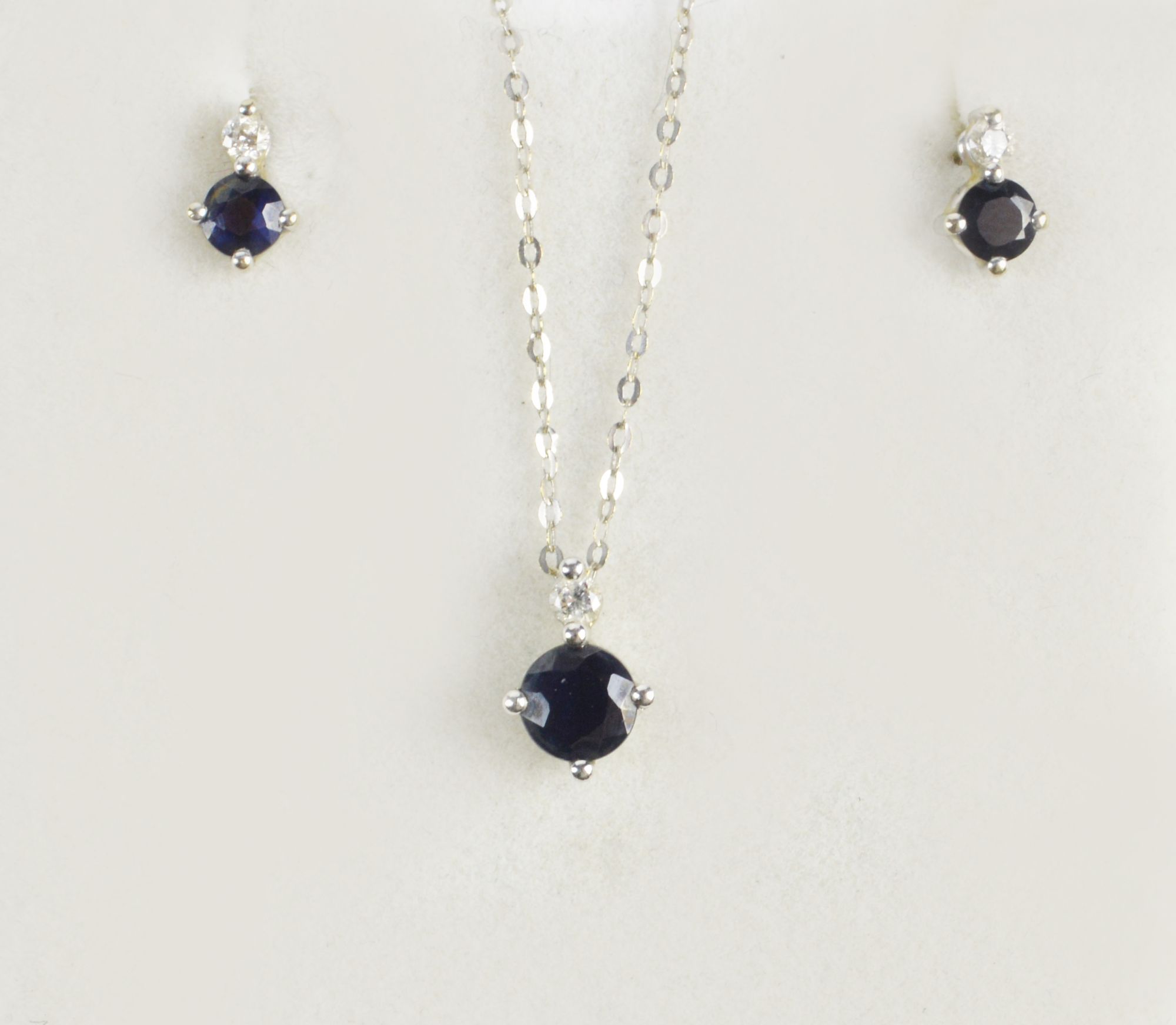 An 18ct white gold sapphire and diamond set pendant and ear-studs, the pendant with approx 0.