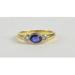 A sapphire and diamond ring, the oval cut mid-blue sapphire flanked by round brilliant cut diamonds,