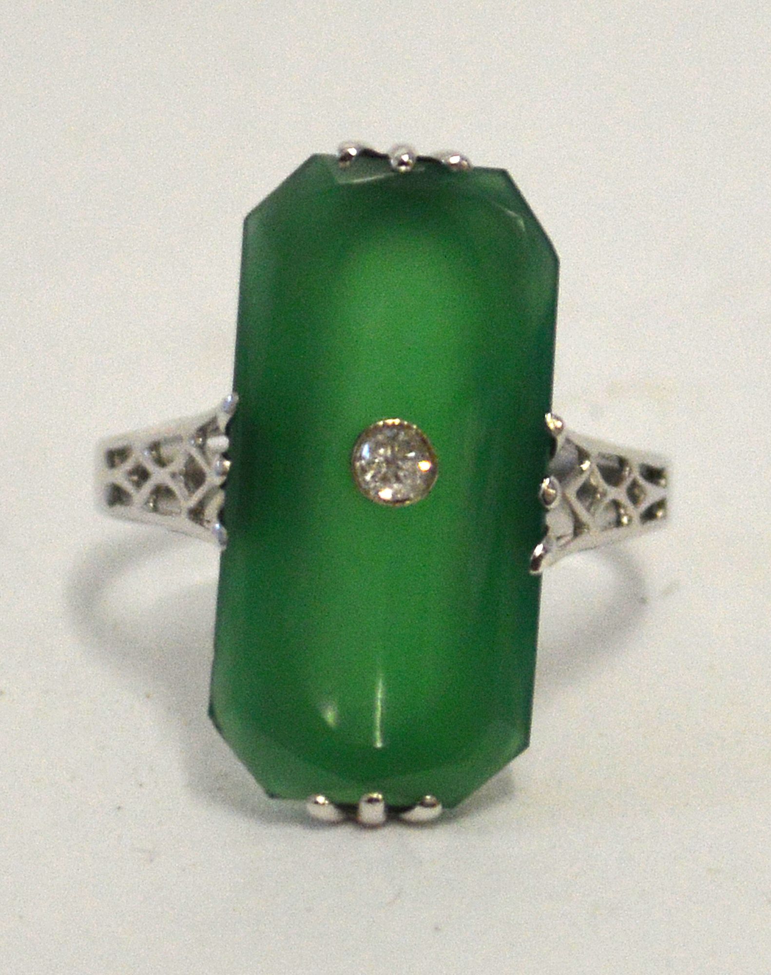 A white metal green chalcedony ring centred with a single diamond,