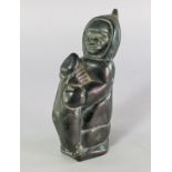 Innuit School, 20th century, a carved soapstone figure of an Eskimo, modelled holding a seal,