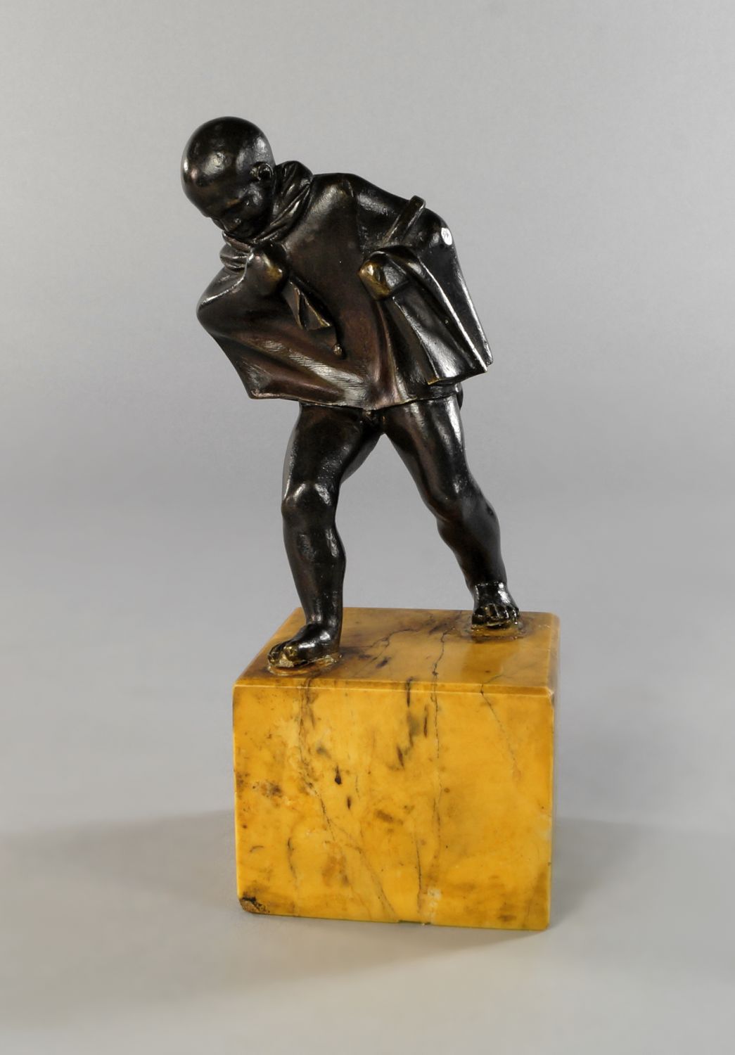 An Italian bronze figure of a young boy, 18th century, personifying Winter, modelled nude wrapped in