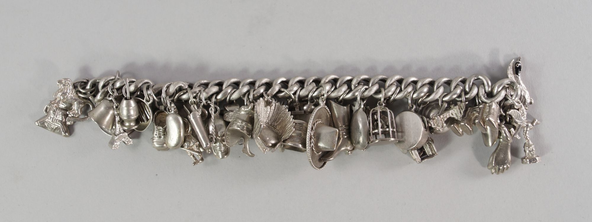 A silver charm bracelet, hung with various silver and white metal charms, approx 17.