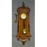 A walnut Vienna regulator, 20th century, with an ornate carved architectural case,