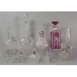 A collection of decanters and silver topped and silver collared scent bottles,