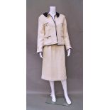 Chanel Boutique: a cream wool open weave skirt and jacket suit with navy blue collar and trim,