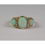 An 18ct gold, three stone opal ring, the central oval opal flanked by six old cut diamonds,